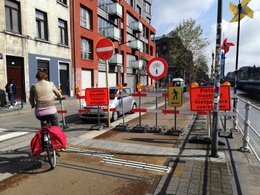 Mei 2021: hef fietspad langs de Koolmijnenkaai is tijdelijk afgesloten voor de aanleg van de fietsers- en voetgangersbrug over het kanaal. Fiersers moeten afstappen